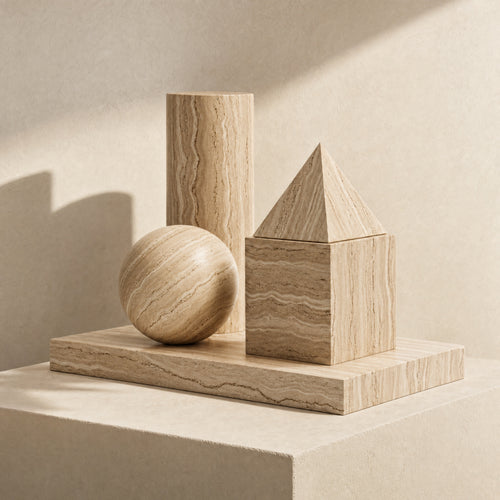 Archetype travertine sculptural objects arranged on an ivory architectural plinth.