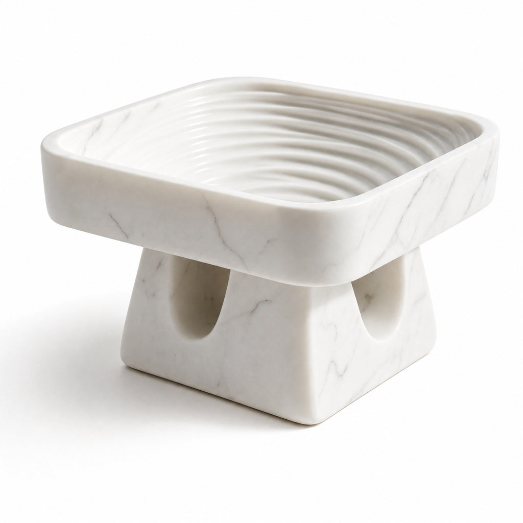 Detail of the Stèle white natural stone bowl, ribbed interior, and sculpted base.